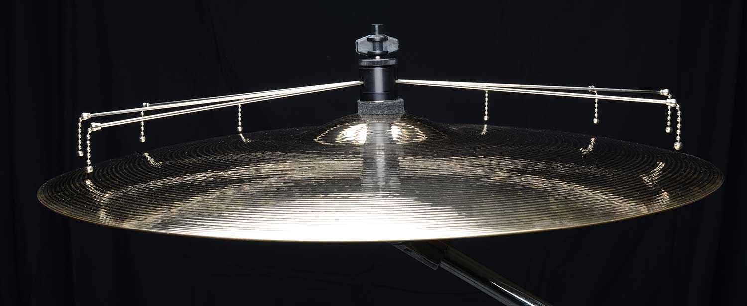 Close-up side view of a Jaspercussion Cymb Siz chain sizzler attached to a ride cymbal, all set against a dark background.